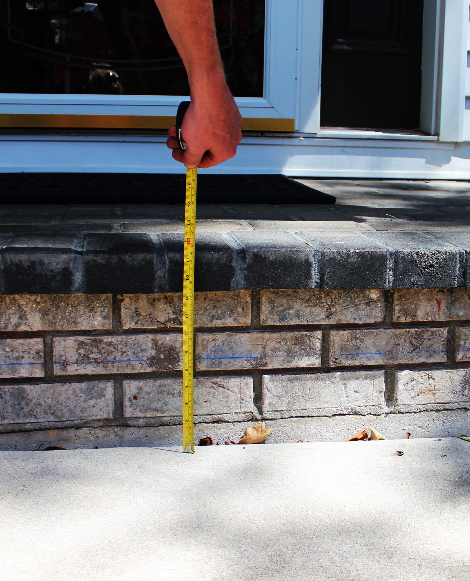 Uneven front entry steps with sunken concrete slab before repair